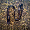 Black lanyard with a brand logo on a patterned fabric background